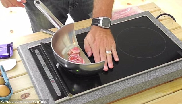 In the final part of the video, two rashers of bacon are placed in the half saucepan and begin to bubble. While the cooking is going on, the demonstrator places his hand on the induction hob next to the pan, to show that the surface remains cool without metal on top of it (pictured)