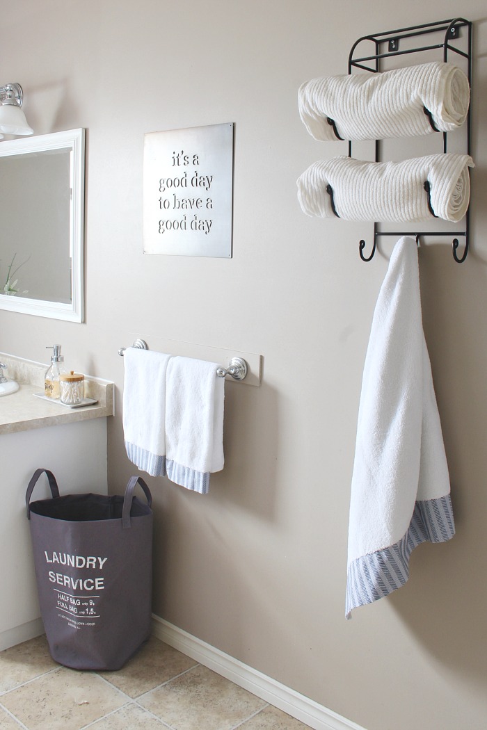 Organized bathroom with towels hung from hooks.